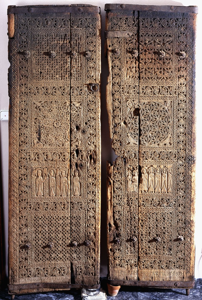 नक्काशीदार अर्मेनियाई अखरोट के दरवाजे की एक जोड़ी, मसीह को छह प्रेरितों और संतों के साथ दर्शाती है, 1312 द्वारा अर्मेनियाई स्कूल