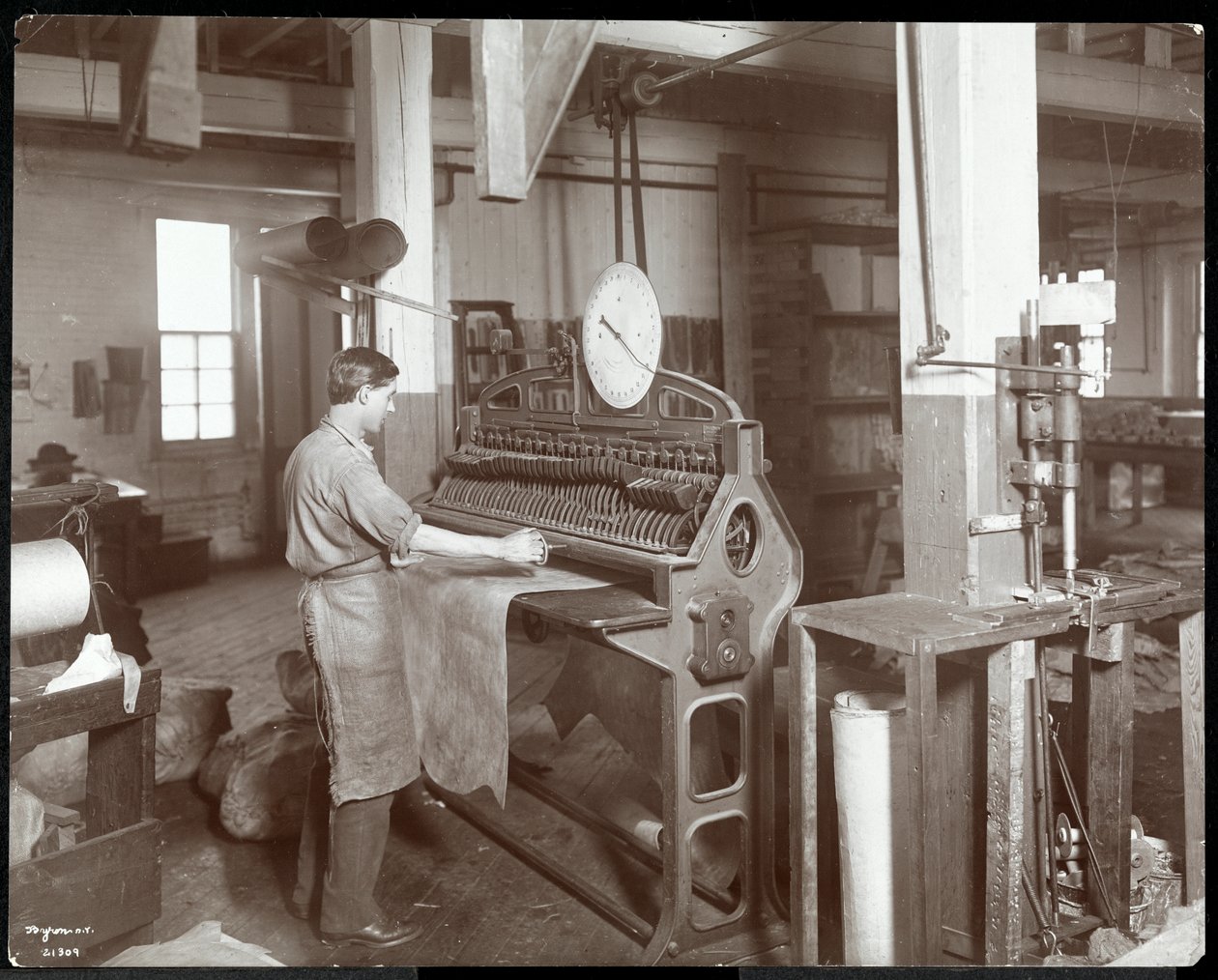 न्यूयॉर्क लेदर बेल्टिंग कंपनी, न्यूयॉर्क में 1906 (सिल्वर जिलेटिन प्रिंट) में चमड़े से काम करने वाले व्यक्ति का आंतरिक दृश्य द्वारा बायरन कंपनी