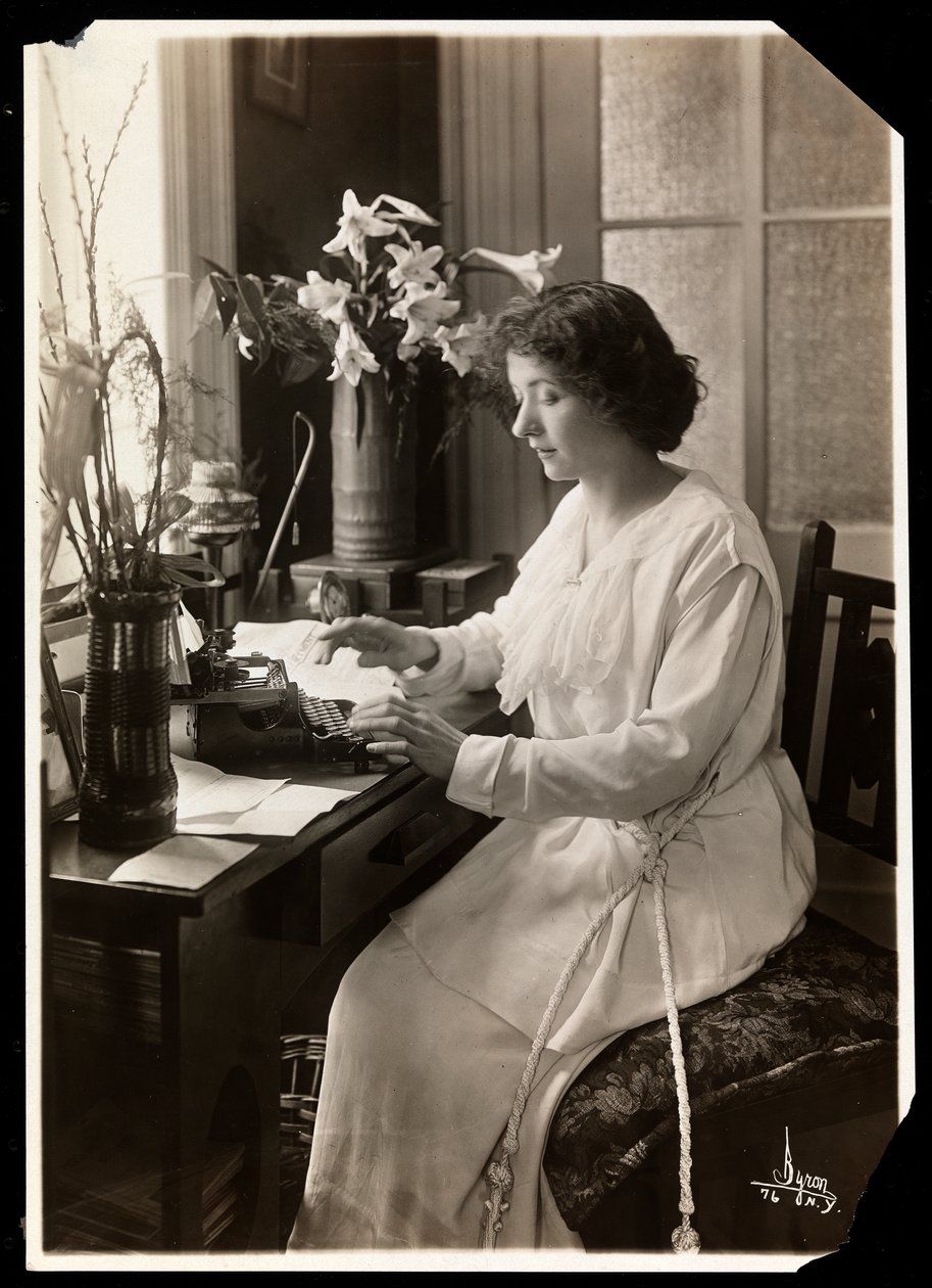 Maude Fealy एक टाइपराइटर पर बैठा, c.1915 (सिल्वर जिलेटिन प्रिंट) द्वारा बायरन कंपनी