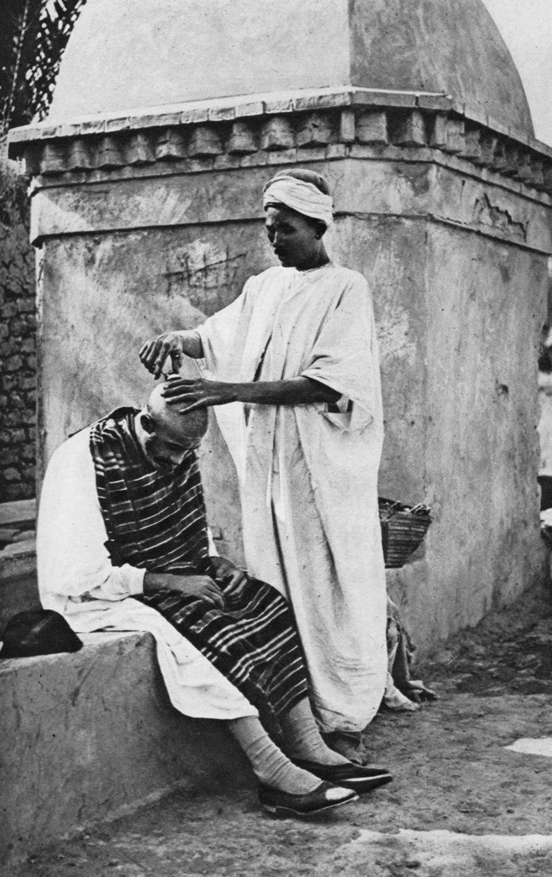 एक सड़क नाई और उसका ग्राहक, अल्जीरिया, अफ्रीका, 1922। द्वारा डोनाल्ड मैकलेश
