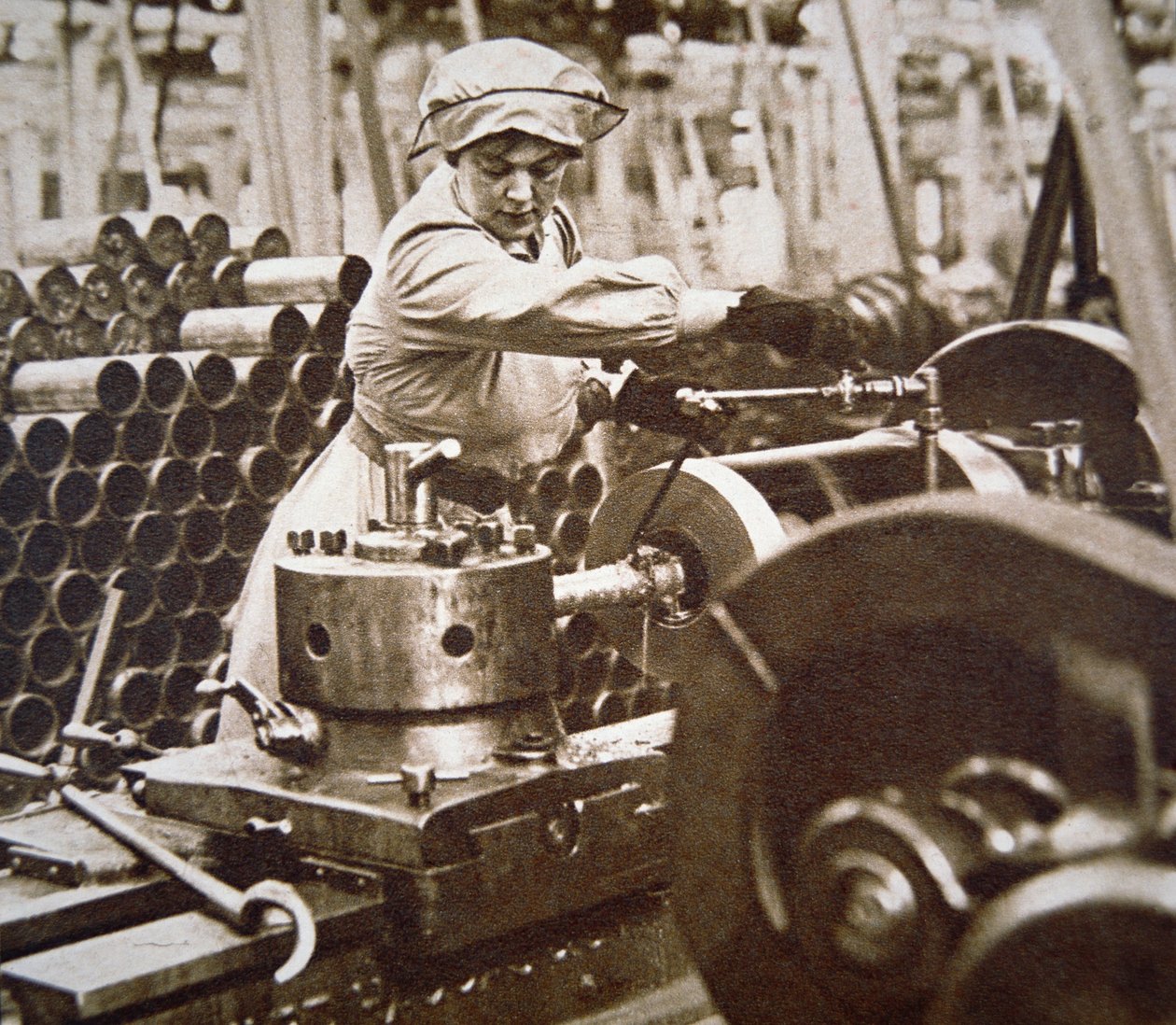 WWI के दौरान ब्रिटेन में एक युद्ध सामग्री कारखाने में महिला कार्यकर्ता (b/w photo) द्वारा अंग्रेजी फोटोग्राफर