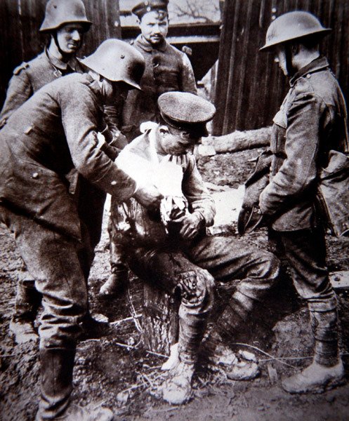 WWI जर्मन मेडिकल अर्दली पश्चिमी मोर्चे पर एक घायल ब्रिटिश सैनिक की देखभाल करता है द्वारा फ़ोटोग्राफ़र जर्मन