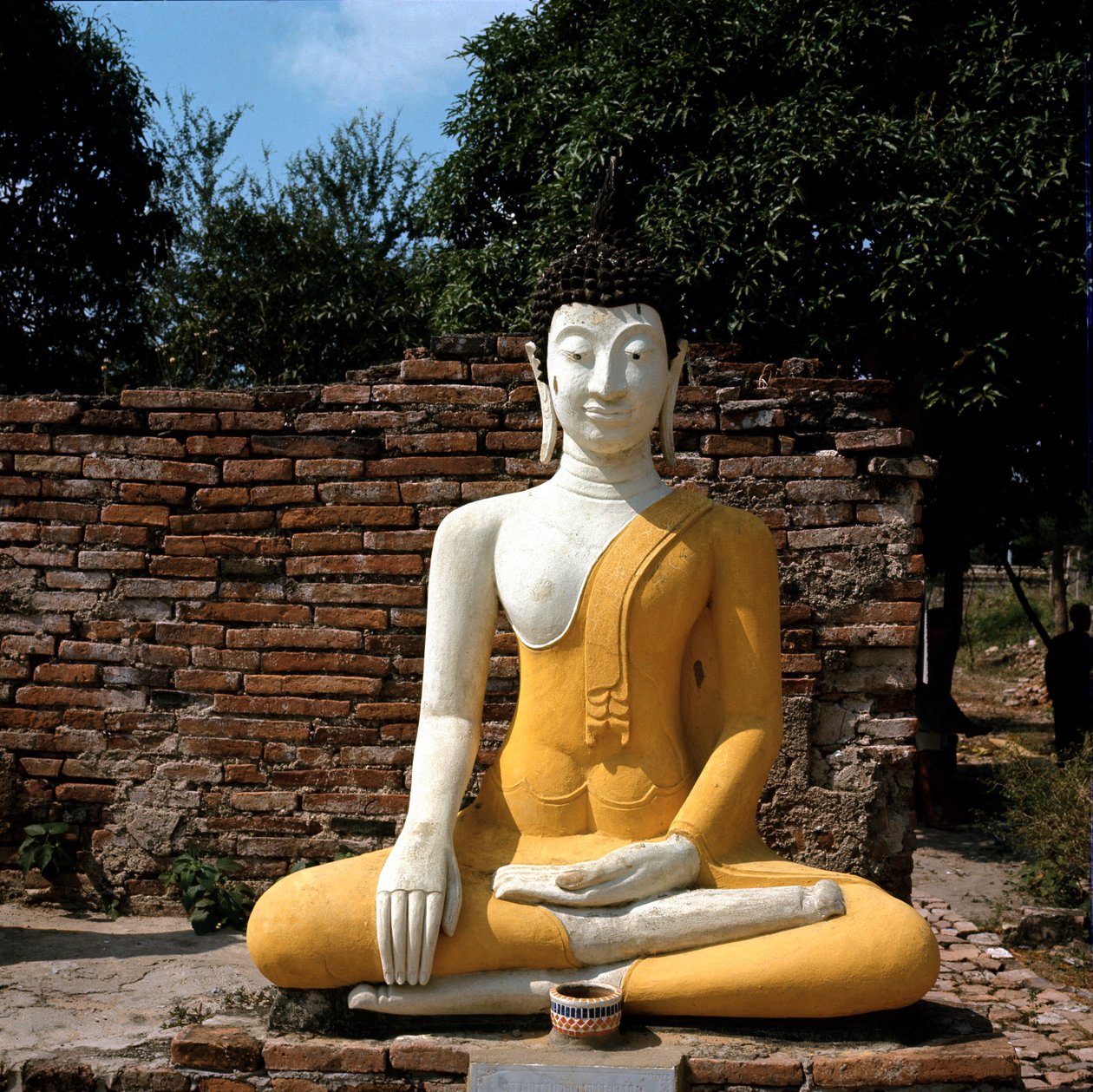 मंदिर के बाहर बुद्ध की एक मूर्ति द्वारा थाई थाई