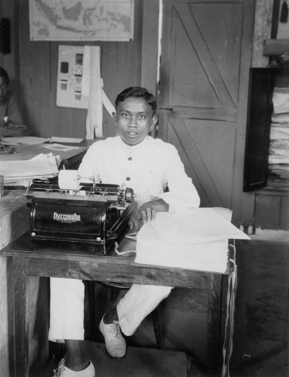 20 वीं सदी के इंडोनेशिया के एक टाइपराइटर पर बैठा एक युवक द्वारा अज्ञात