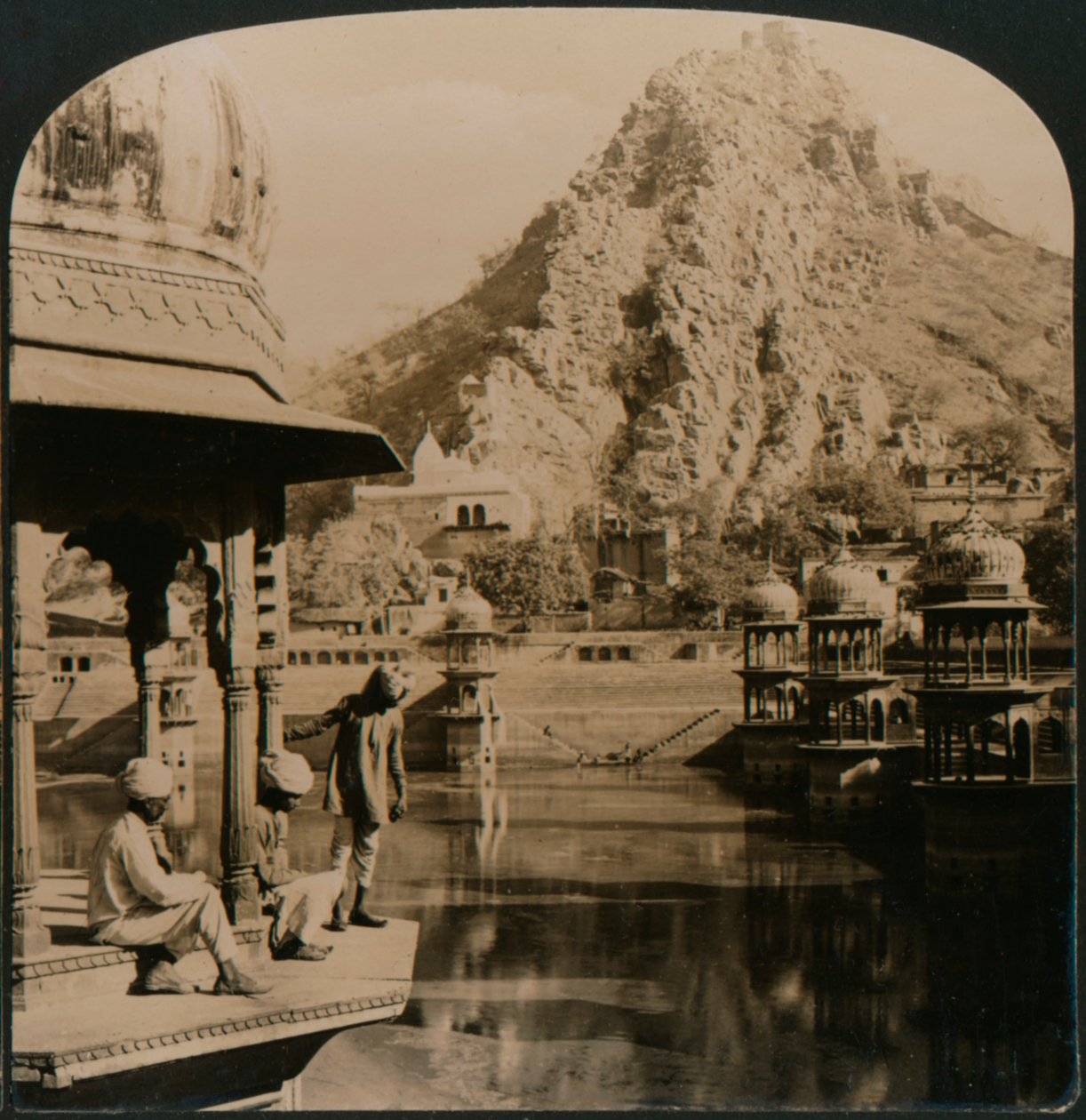 अलवर का पवित्र तालाब, महलों और मंदिरों से घिरा, सुंदरता को पार करने का एक दृश्य, भारत, 1907 द्वारा अज्ञात