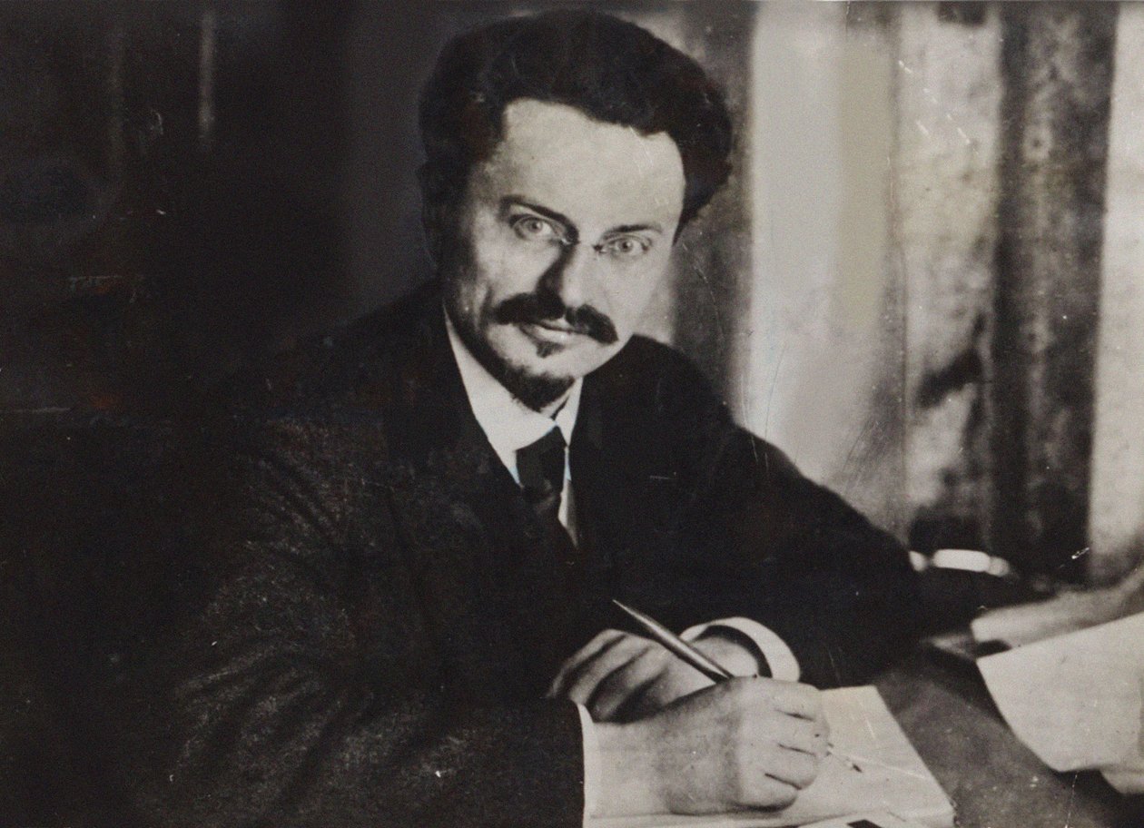 लियोन ट्रॉट्स्की अपने लेखन डेस्क पर, 1920 के दशक की शुरुआत में। द्वारा अज्ञात