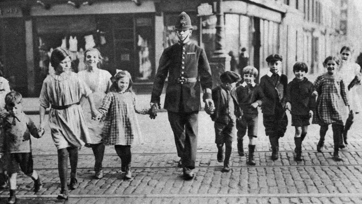 सड़क, ईस्ट एंड, लंदन, 1926-1927 में स्कूली बच्चों की मदद करते पुलिसकर्मी द्वारा अज्ञात