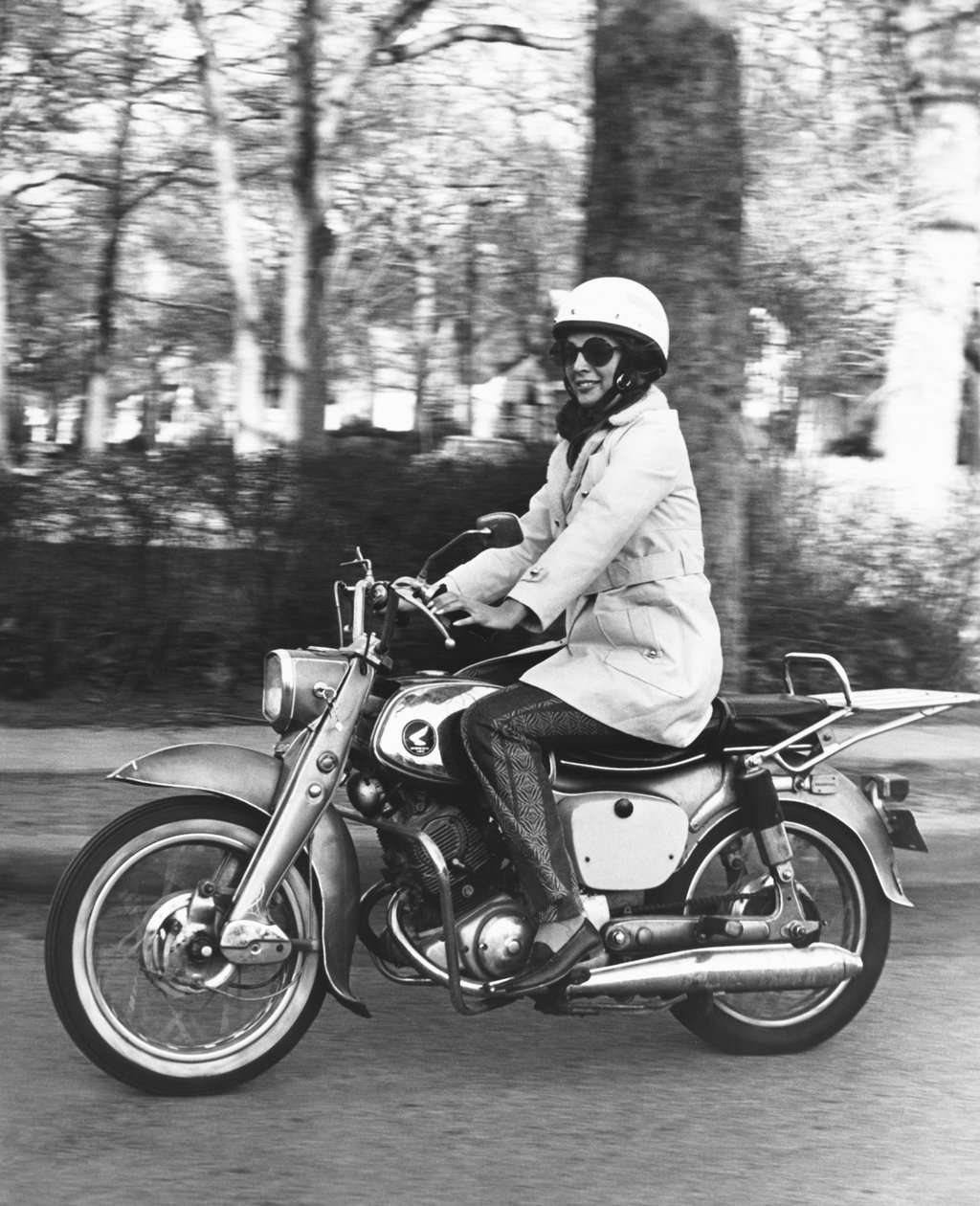 संयुक्त राज्य अमेरिका: c.1961 अपनी होंडा 160 मोटरसाइकिल की सवारी करती एक महिला। (बी/डब्ल्यू फोटो) द्वारा अज्ञात