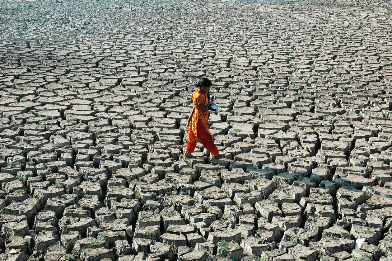 बांग्लादेश के ढाका के हजारीबाग में बुरिगंगा के सूखे नदी के तल पर एक युवा लड़की और उसकी बहन नीचे के गरीबी स्तर के समूह से। 4 मार्च, 2005। द्वारा अज्ञात अज्ञात