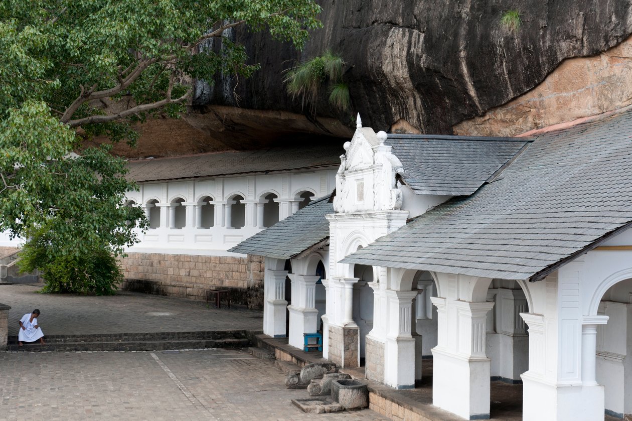 एक चट्टान की दीवार के नीचे सफेद इमारत; गुफा मंदिर; स्वर्ण मंदिर; दांबुला; श्रीलंका; एशिया द्वारा अज्ञात