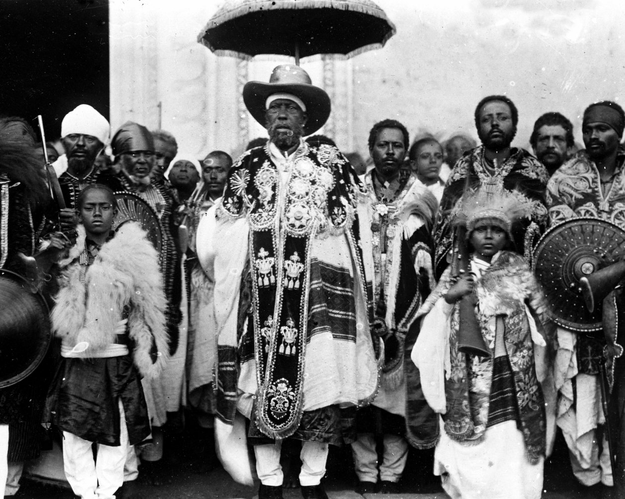 राजा मेनेलिक द्वितीय (1844 - 1913) अपने दरबार से घिरा हुआ था। इथियोपिया। द्वारा अज्ञात फोटोग्राफर