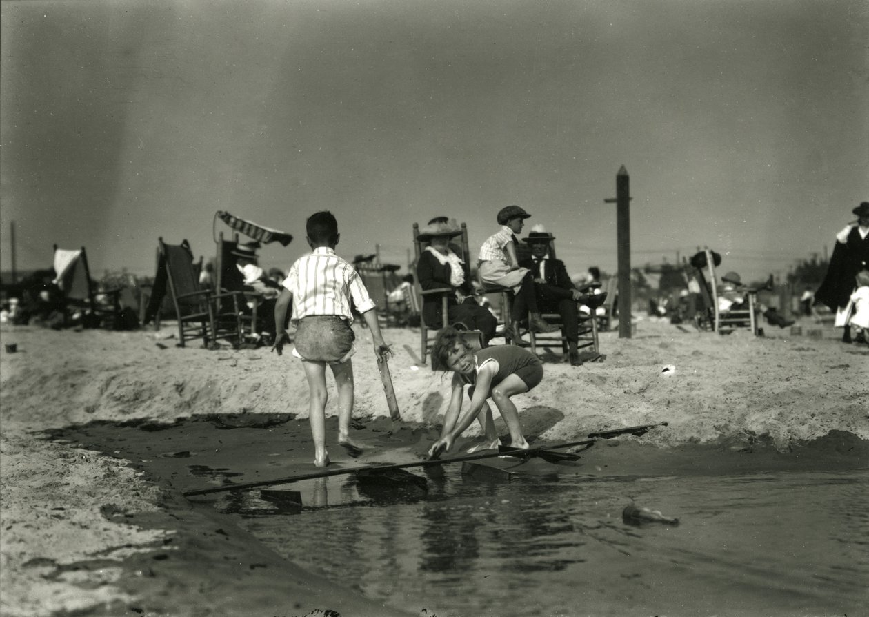 दो बच्चे उथले, कोनी द्वीप में लकड़ी के स्क्रैप के साथ खेलते हैं, c.1910-21 द्वारा विलियम डेविस हसलर