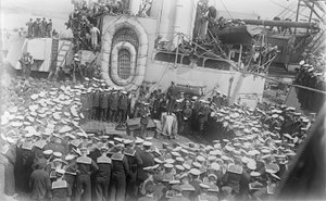 21 मई 1916 को डेवॉन, इंग्लैंड के डॉकयार्ड में HMAS ऑस्ट्रेलिया के डेक पर उन्हें संबोधित करते हुए ऑस्ट्रेलिया के प्रधान मंत्री माननीय विलियम मॉरिस (बिली) ह्यूजेस के चारों ओर भीड़ द्वारा ऑस्ट्रेलियाई फोटोग्राफर