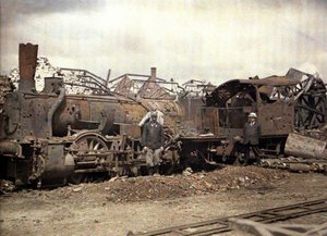 लोकोमोटिव और रेलवे कार को बुरी तरह से क्षतिग्रस्त वक्सारोट डिस्टिलरी, कफिस, आइज़ेन, फ्रांस, 1917 (ऑटोक्रोम) के खंडहर के सामने जला