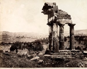 वैले देई टेम्पली, एग्रीजेंटो में कैस्टर और पोलक्स के मंदिर के एक प्रवेश द्वार का समर्थन करने वाले शेष चार स्तंभों का दृश्य। पृष्ठभूमि में शहर का एक पैनोरमा दिखाई दे रहा है द्वारा जियोर्जियो गर्मी