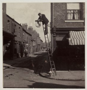आदमी एक गैस स्ट्रीट लाइट की सफाई करता है, c 1905 द्वारा अज्ञात
