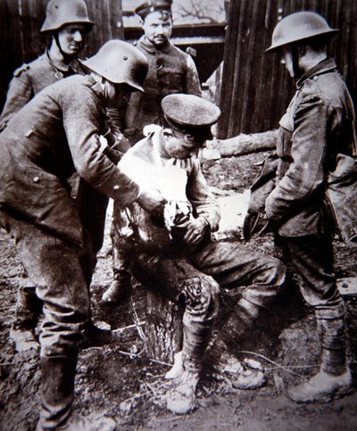 WWI जर्मन मेडिकल अर्दली पश्चिमी मोर्चे पर एक घायल ब्रिटिश सैनिक की देखभाल करता है द्वारा फ़ोटोग्राफ़र जर्मन
