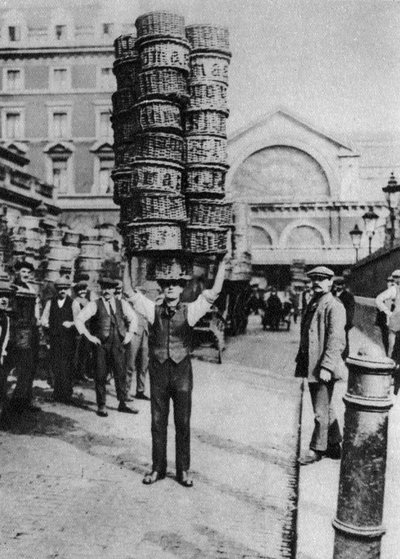 एक आदमी अपने सिर पर कई टोकरियाँ ले जा रहा है, कोवेन्ट गार्डन, लंदन, 1926-1927 द्वारा अज्ञात