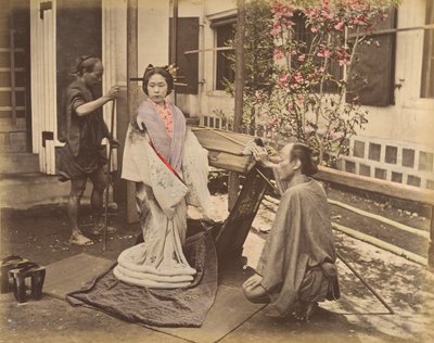 [पारंपरिक पोशाक में दो पुरुषों के साथ पोज़ देती जापानी महिला], 1870 का दशक। द्वारा अज्ञात