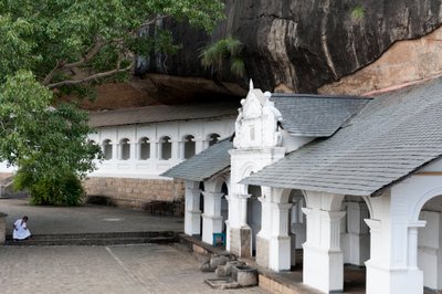 एक चट्टान की दीवार के नीचे सफेद इमारत; गुफा मंदिर; स्वर्ण मंदिर; दांबुला; श्रीलंका; एशिया द्वारा अज्ञात